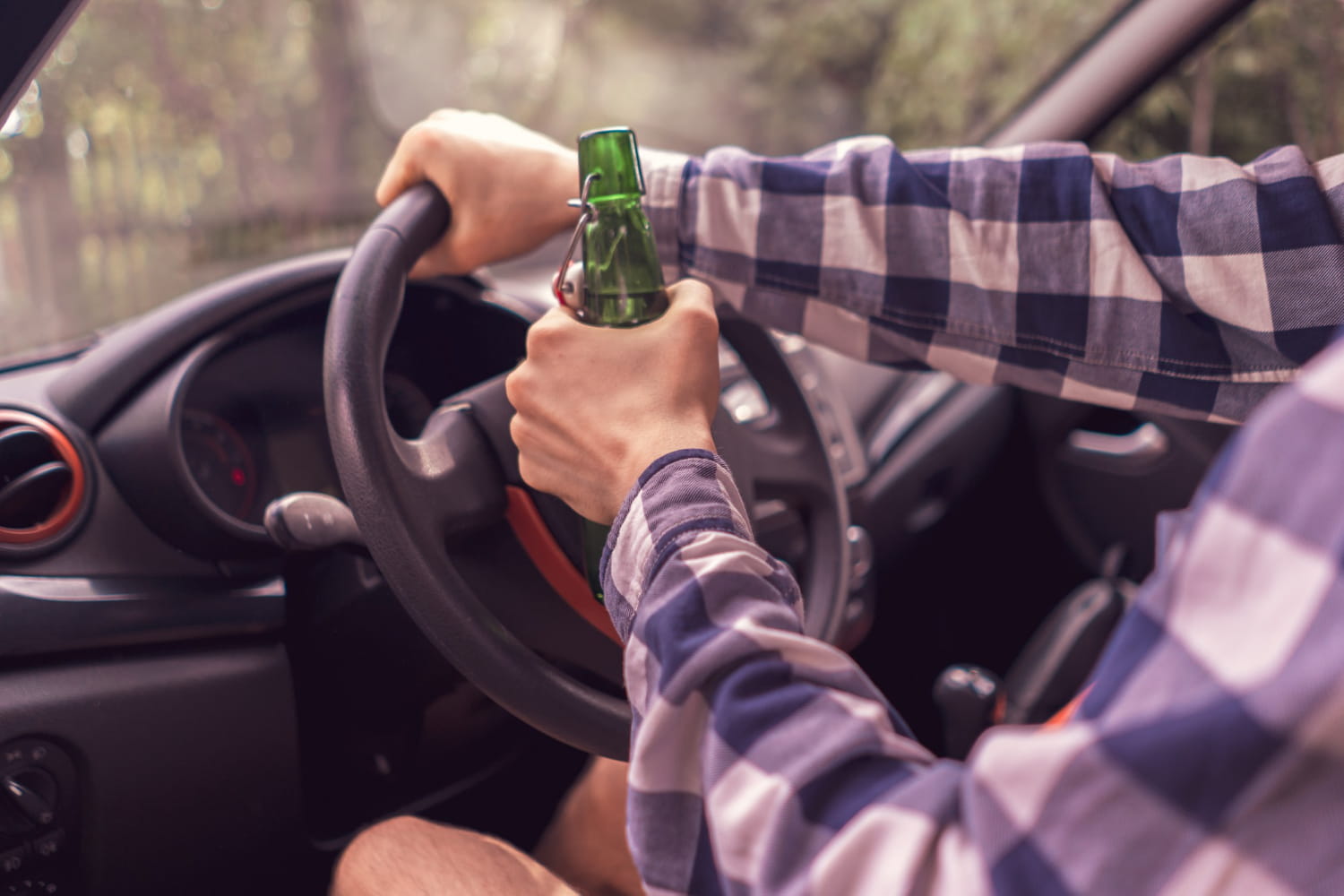 man driving and car and drinking