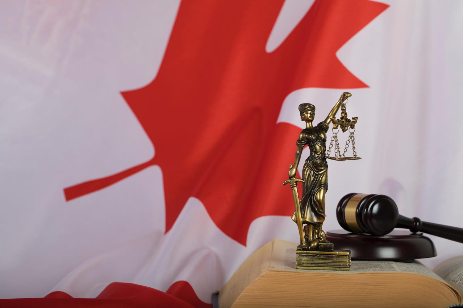 themis figurine in front of canada flag